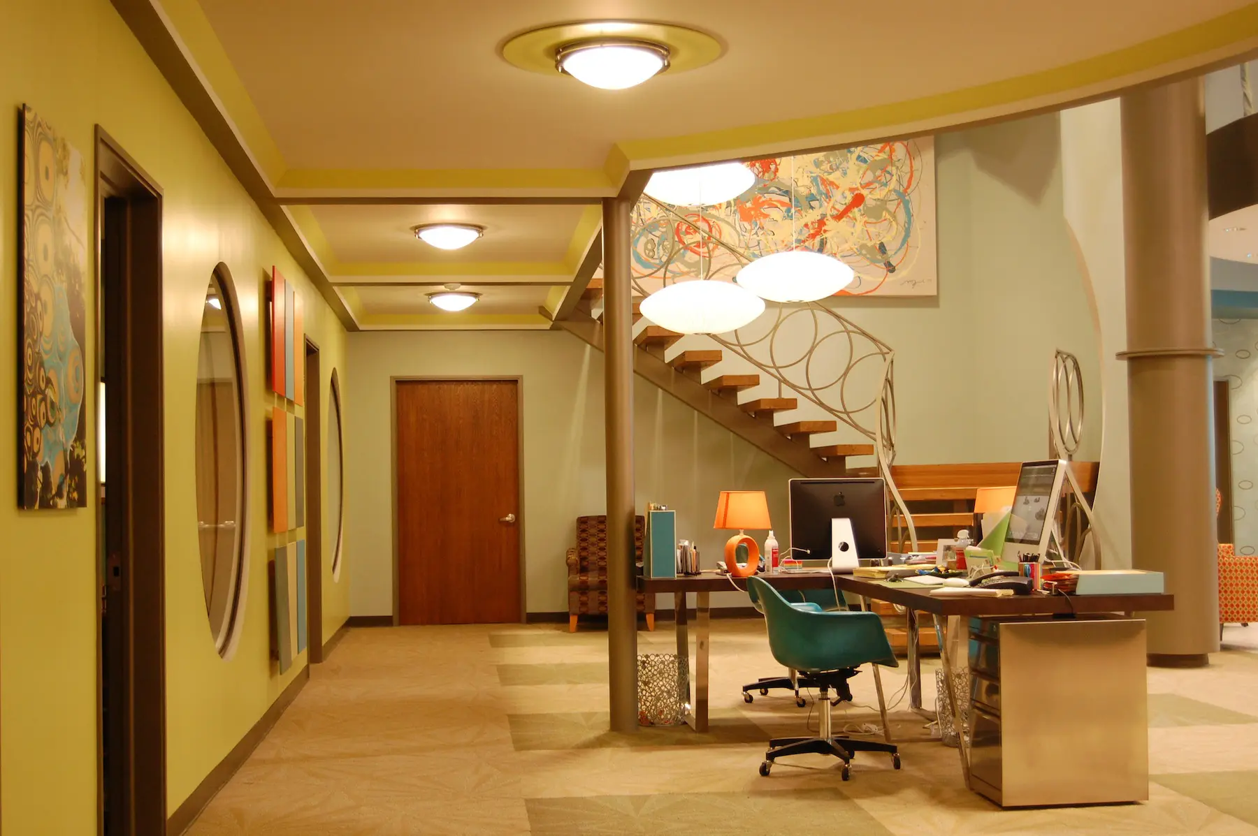 Open office layout with desk and artwork